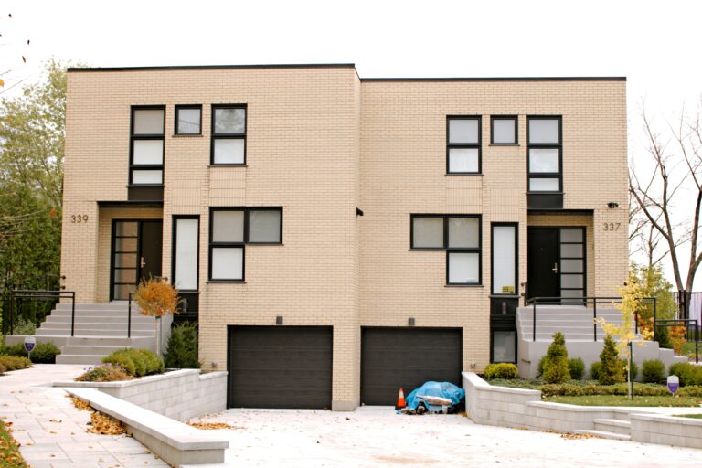 Modern two-unit duplex with separate entrances and garages, representing a house-hack real estate investment