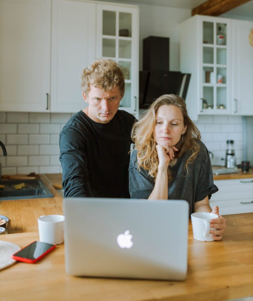 A couple reviewing their duplex investment strategy together on a laptop at home